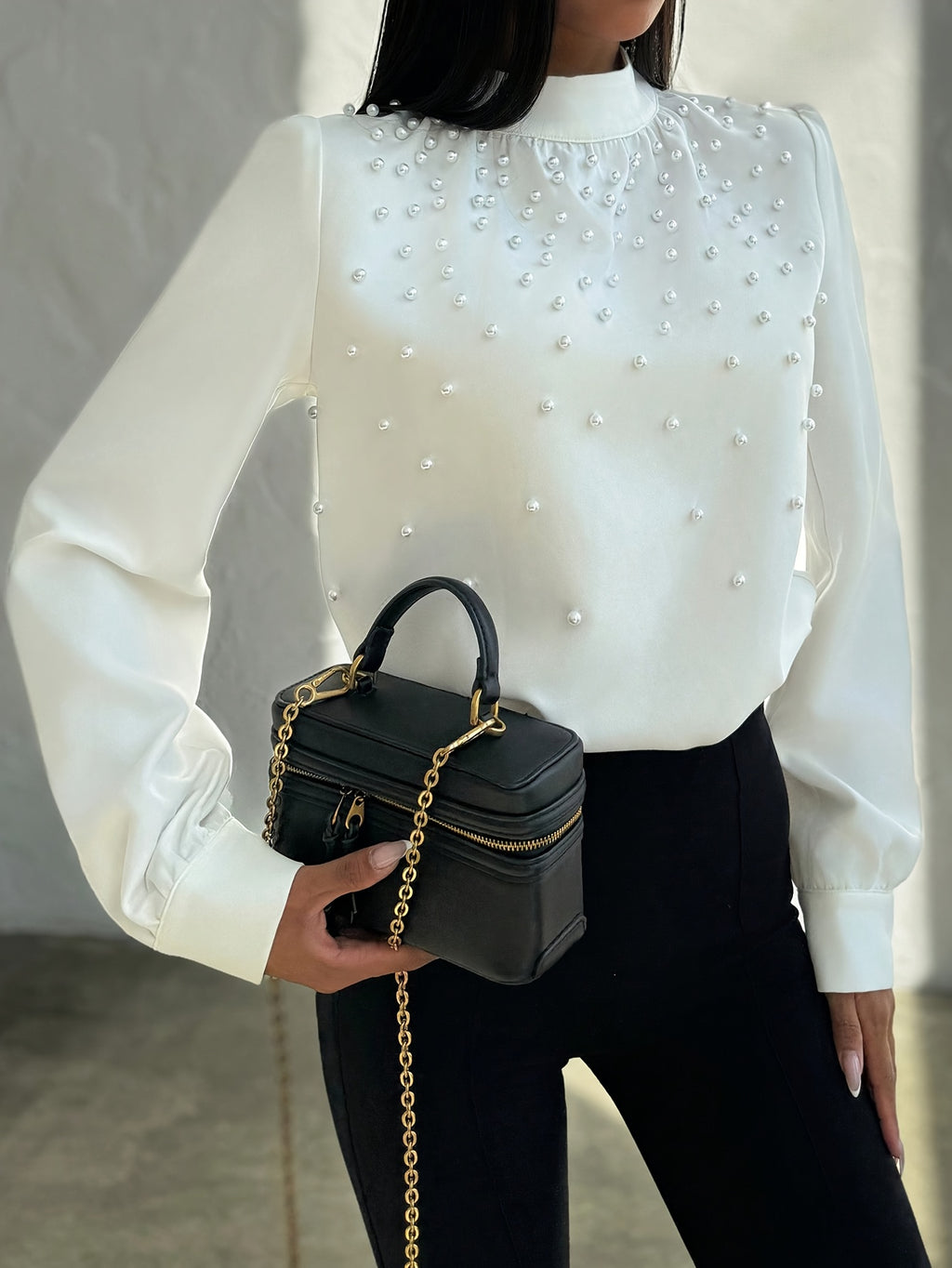 Blusa elegante para mujer con cuello adornado: camisa blanca de manga larga con botones de cuentas en la parte delantera y cuello alto estructurado.