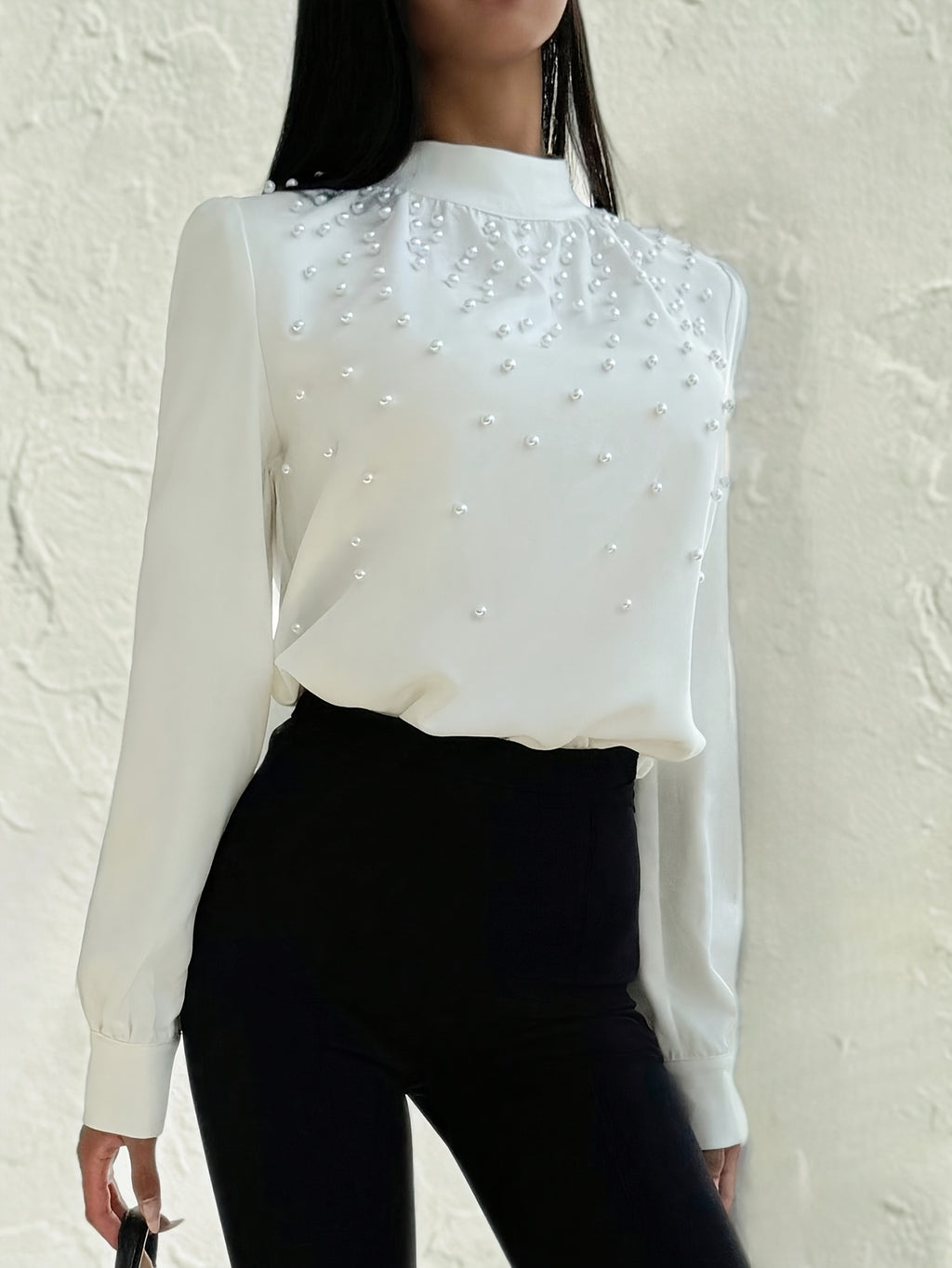 Blusa elegante para mujer con cuello adornado: camisa blanca de manga larga con botones de cuentas en la parte delantera y cuello alto estructurado.