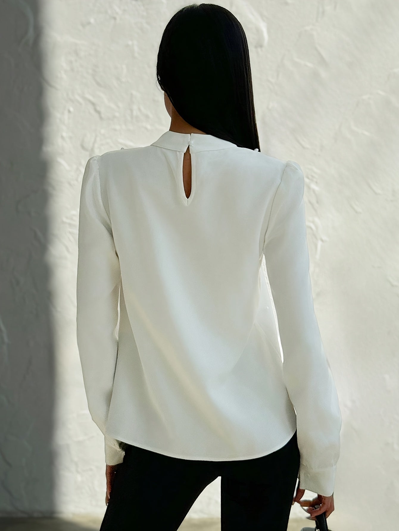 Blusa elegante para mujer con cuello adornado: camisa blanca de manga larga con botones de cuentas en la parte delantera y cuello alto estructurado.