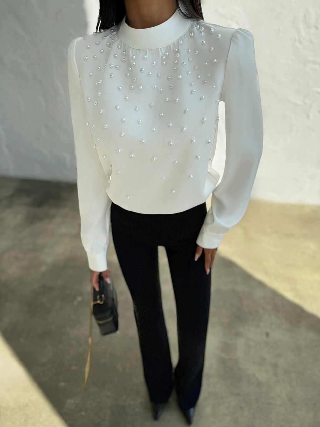 Blusa elegante para mujer con cuello adornado: camisa blanca de manga larga con botones de cuentas en la parte delantera y cuello alto estructurado.