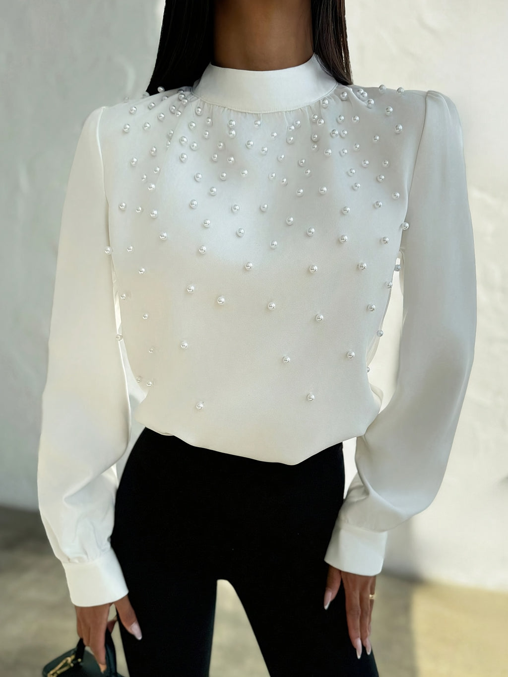 Blusa elegante para mujer con cuello adornado: camisa blanca de manga larga con botones de cuentas en la parte delantera y cuello alto estructurado.