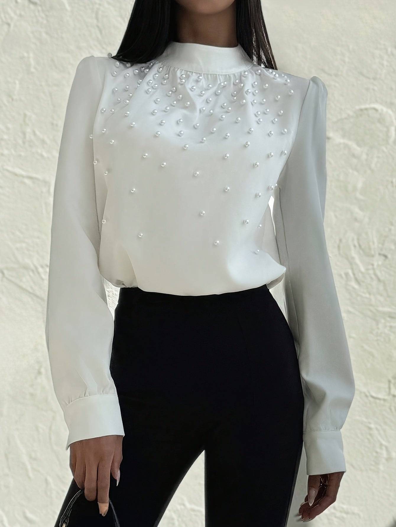 Blusa elegante para mujer con cuello adornado: camisa blanca de manga larga con botones de cuentas en la parte delantera y cuello alto estructurado.