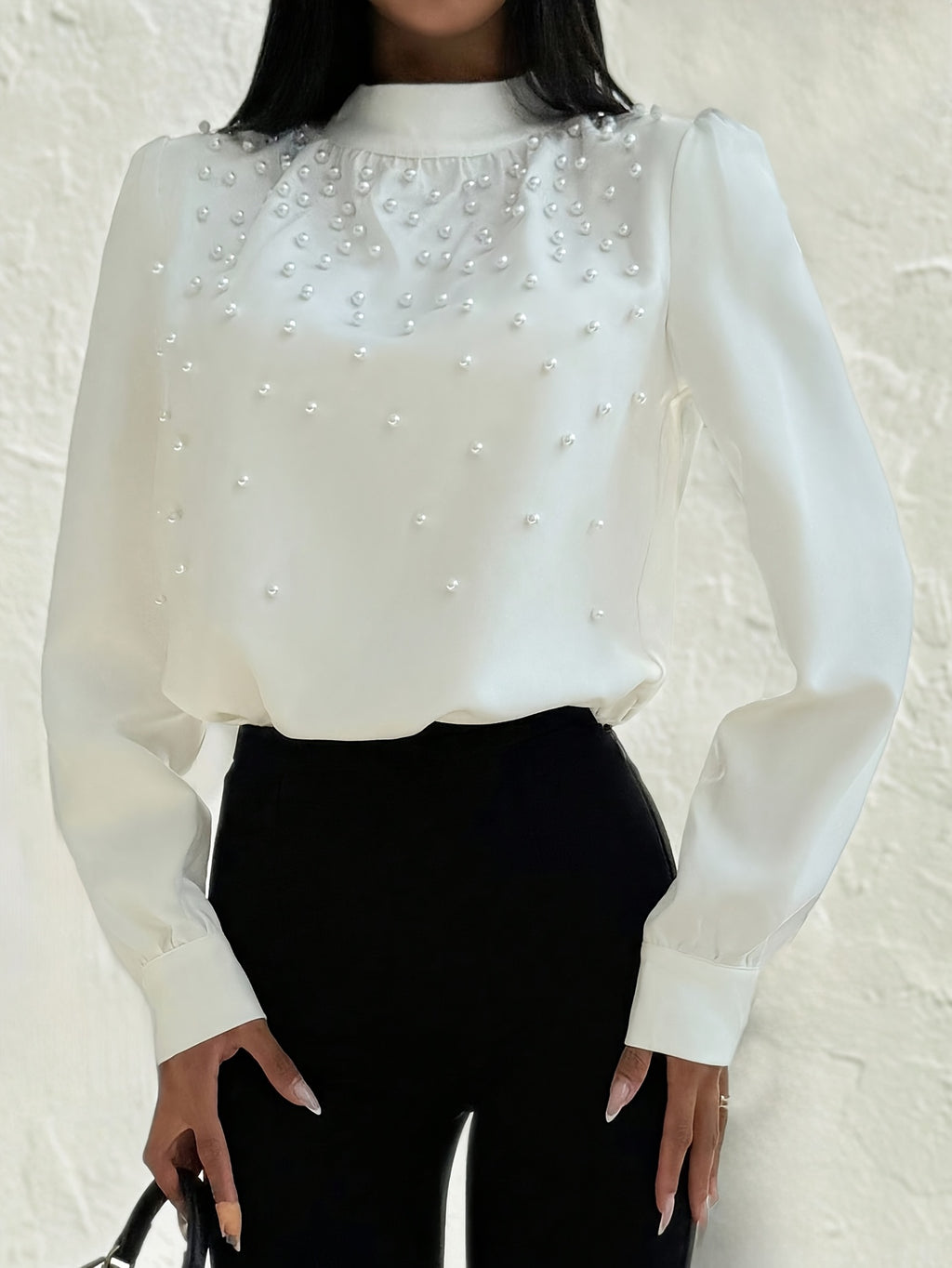 Blusa elegante para mujer con cuello adornado: camisa blanca de manga larga con botones de cuentas en la parte delantera y cuello alto estructurado.