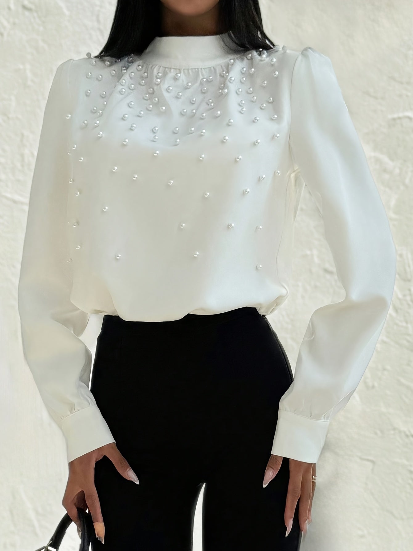 Blusa elegante para mujer con cuello adornado: camisa blanca de manga larga con botones de cuentas en la parte delantera y cuello alto estructurado.